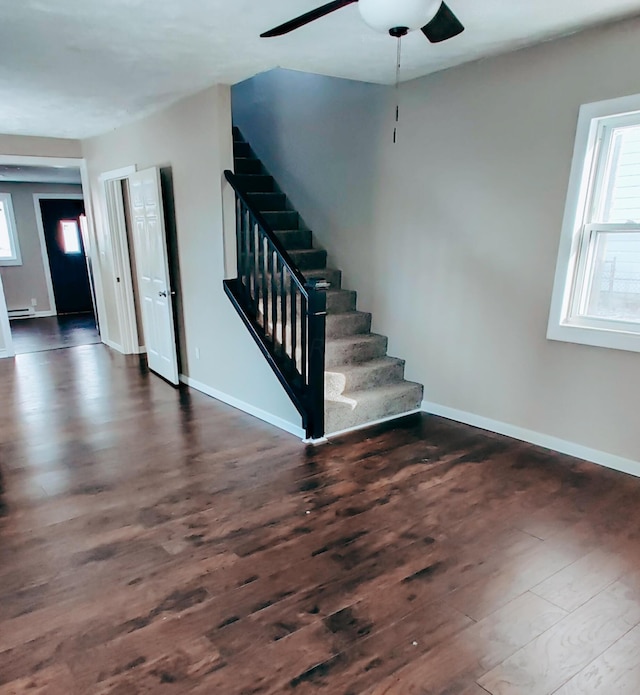 stairway featuring hardwood / wood-style floors, ceiling fan, and a baseboard heating unit