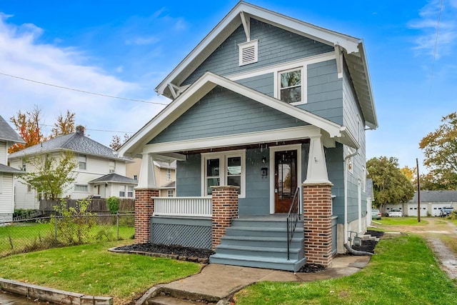 view of front of home featuring covered porch and a front lawn