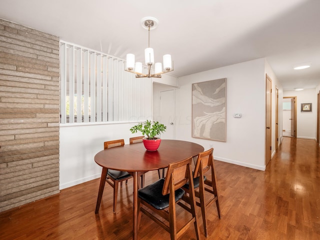 dining space featuring hardwood / wood-style floors and a chandelier