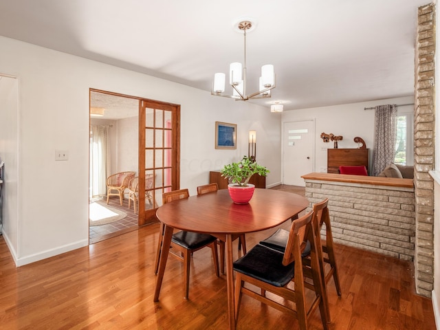 dining area with hardwood / wood-style floors and a chandelier