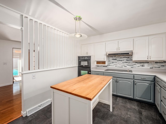 kitchen featuring pendant lighting, a center island, black appliances, gray cabinets, and dark hardwood / wood-style flooring