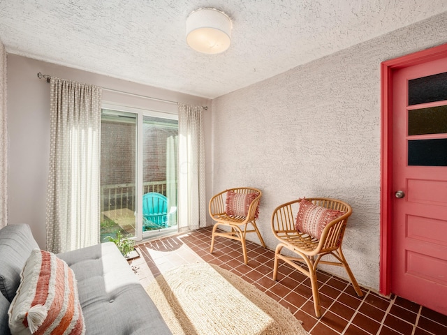 sitting room with dark tile patterned flooring and a textured ceiling