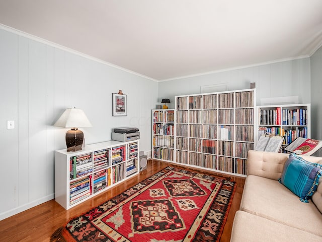 living area with hardwood / wood-style floors and crown molding