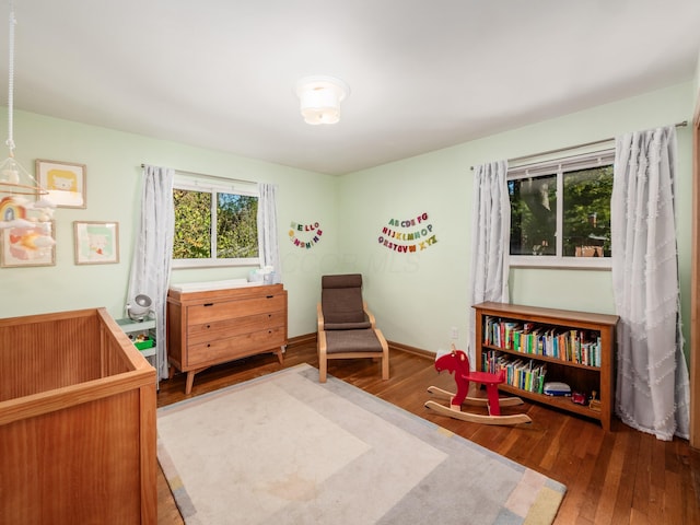 bedroom featuring a crib and dark hardwood / wood-style floors