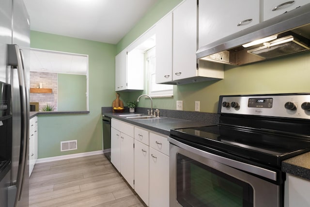 kitchen featuring white cabinets, appliances with stainless steel finishes, light hardwood / wood-style flooring, and sink