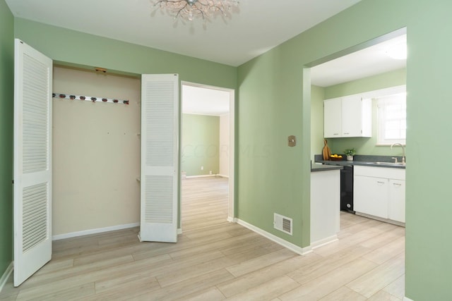 kitchen featuring white cabinetry, sink, and light hardwood / wood-style floors