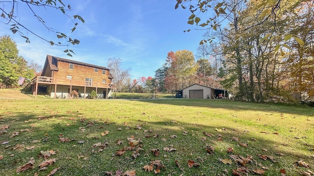 view of yard featuring a garage, a deck, and an outbuilding