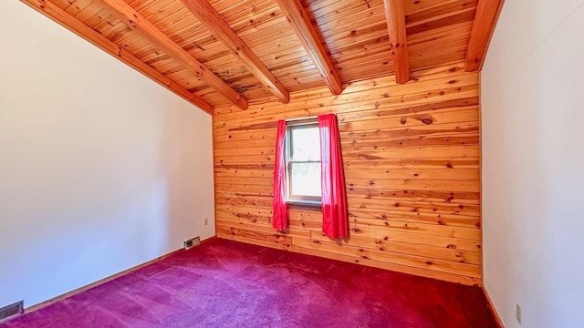 spare room featuring vaulted ceiling with beams, wooden walls, carpet, and wooden ceiling