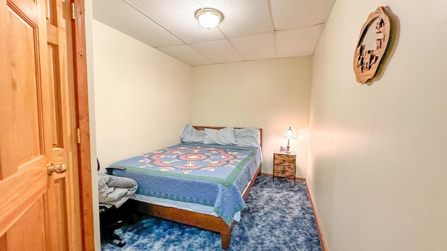 bedroom with a drop ceiling and carpet floors