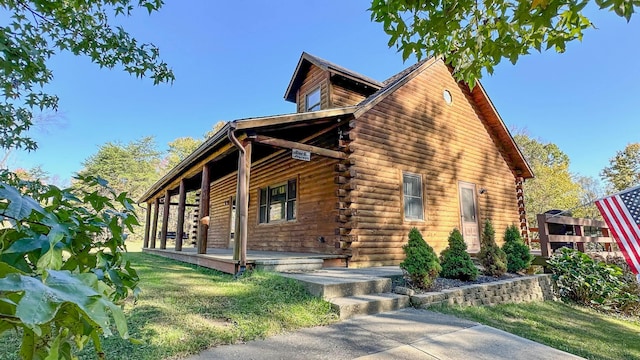 view of side of property featuring a lawn and covered porch