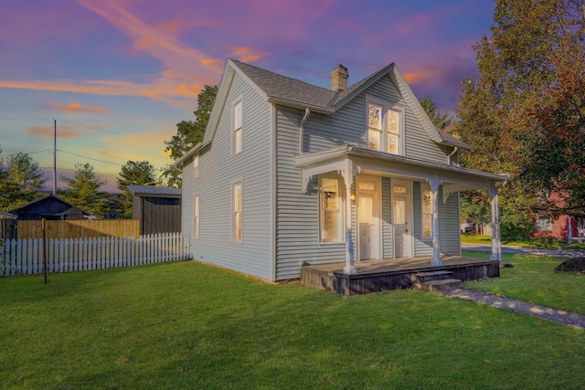 view of front of house with a porch and a yard