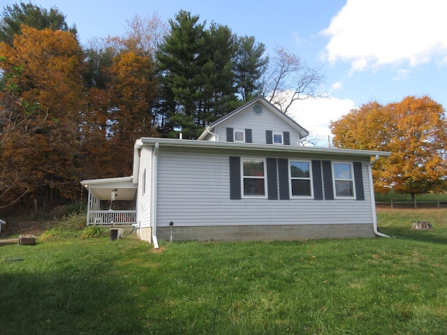 view of home's exterior with a lawn and covered porch