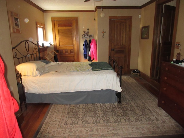 bedroom with ceiling fan, crown molding, and dark wood-type flooring