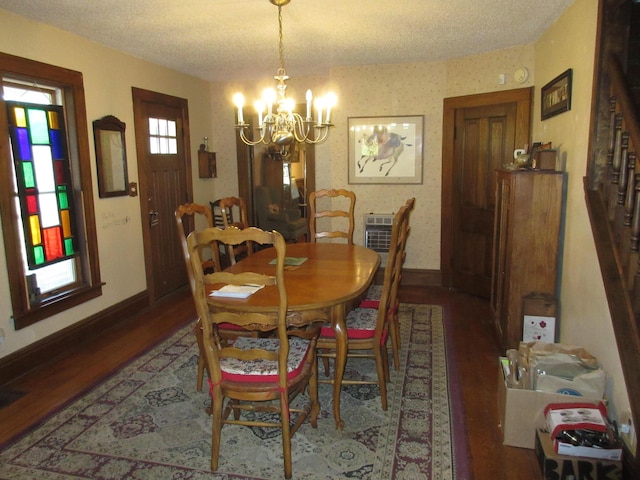 dining space featuring wood-type flooring, a textured ceiling, and an inviting chandelier