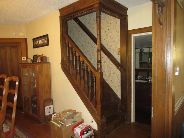 stairs featuring hardwood / wood-style floors and a textured ceiling