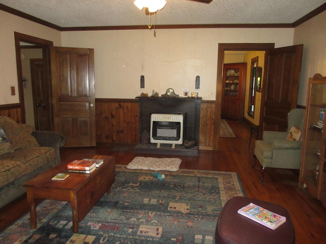 living room with heating unit, dark hardwood / wood-style flooring, a textured ceiling, and ornamental molding