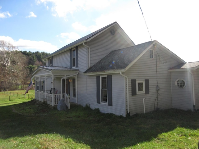 rear view of house with a porch and a lawn