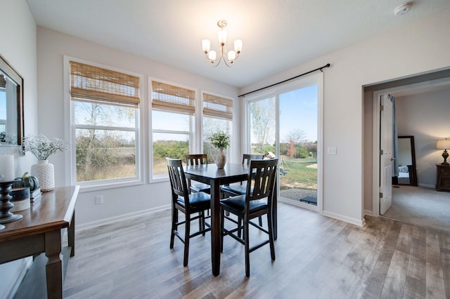 dining area featuring a chandelier, light hardwood / wood-style floors, and a wealth of natural light