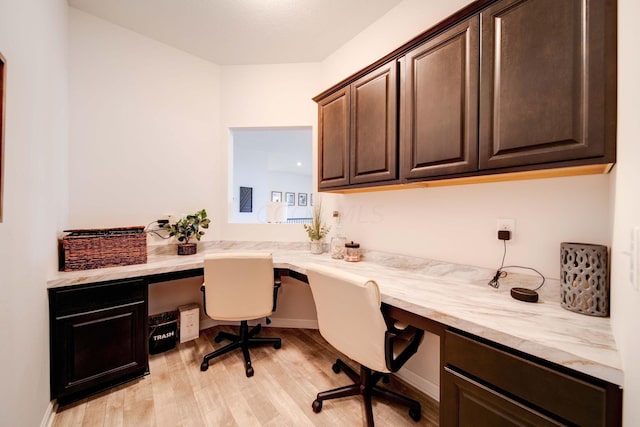 home office with built in desk and light wood-type flooring