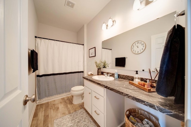 bathroom with vanity, wood-type flooring, and toilet