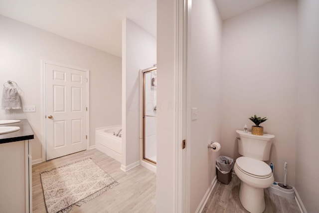 full bathroom featuring hardwood / wood-style flooring, vanity, toilet, and independent shower and bath