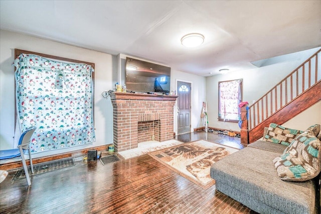 living room featuring hardwood / wood-style floors and a brick fireplace