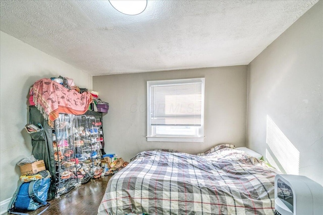 bedroom featuring hardwood / wood-style floors and a textured ceiling