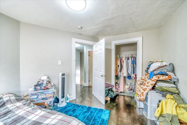 bedroom featuring a textured ceiling, a closet, and dark wood-type flooring