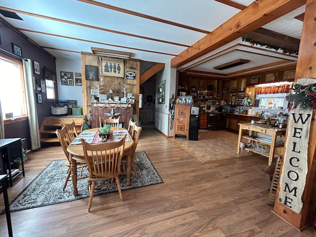 dining space featuring beamed ceiling and hardwood / wood-style flooring