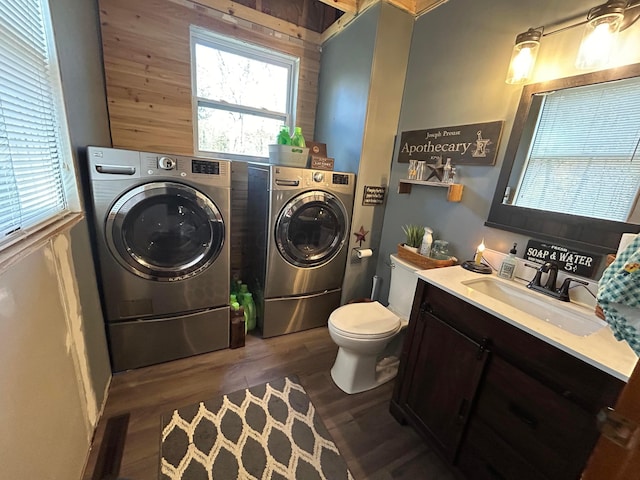 laundry area with sink, dark wood-type flooring, and independent washer and dryer