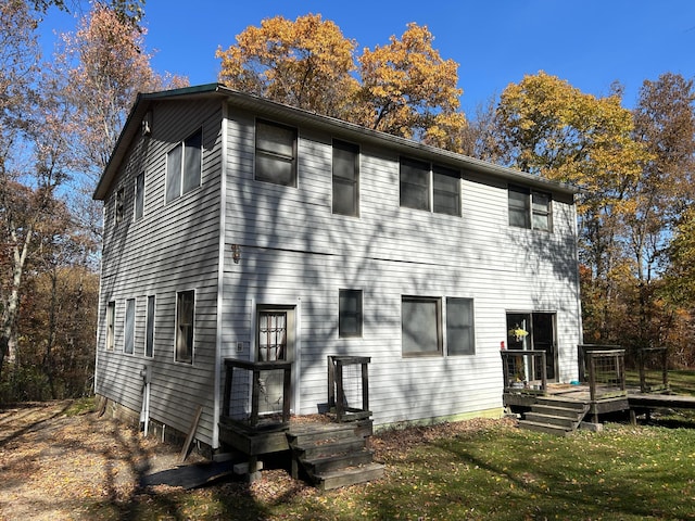 rear view of house with a lawn and a wooden deck