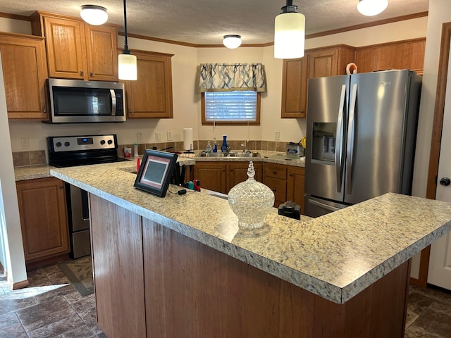 kitchen with a textured ceiling, stainless steel appliances, crown molding, sink, and decorative light fixtures