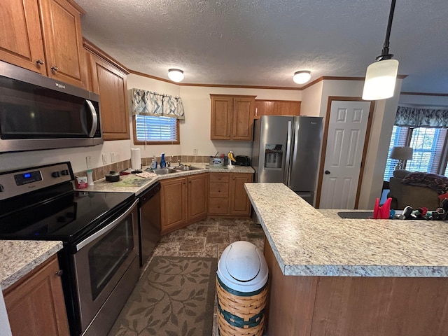 kitchen featuring a wealth of natural light, sink, stainless steel appliances, and decorative light fixtures