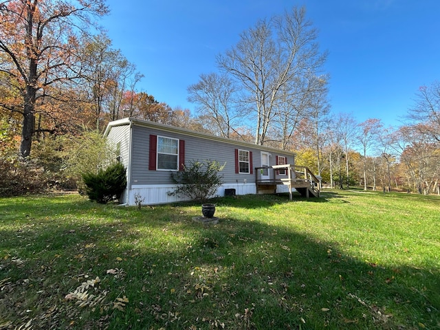 view of side of property featuring a yard and a wooden deck