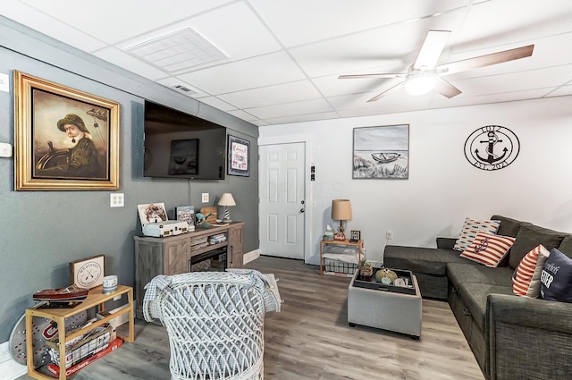 living room featuring hardwood / wood-style flooring, a paneled ceiling, and ceiling fan