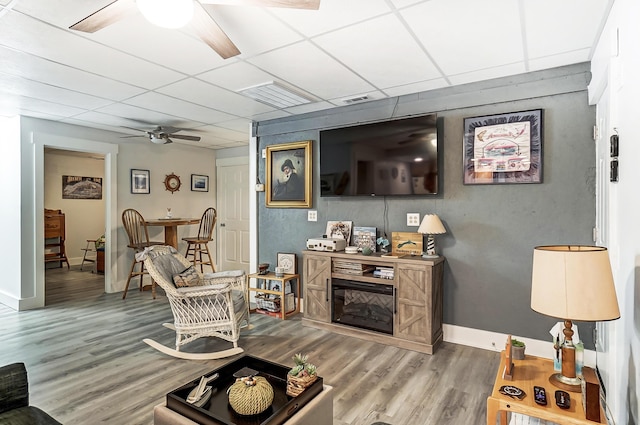 living room with a paneled ceiling, ceiling fan, and wood-type flooring