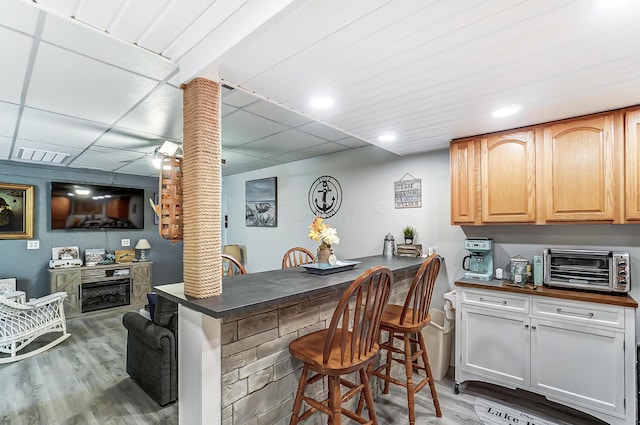 bar featuring ceiling fan and light hardwood / wood-style flooring