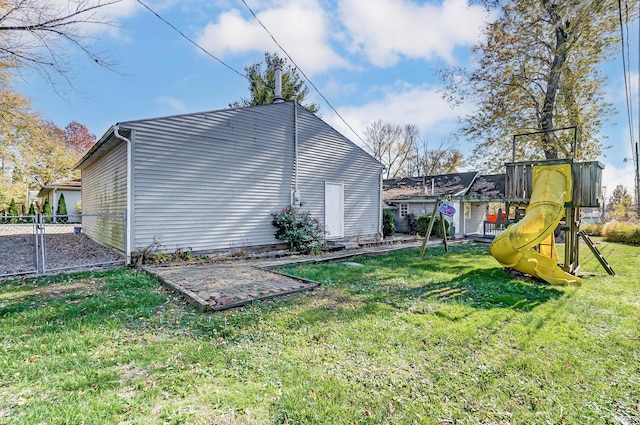 view of side of home with a lawn and a playground