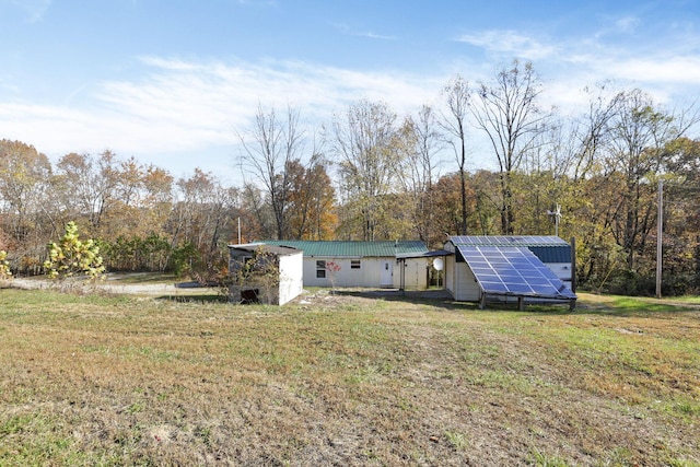 rear view of property featuring solar panels