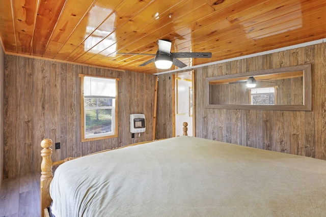 bedroom featuring wooden ceiling, wooden walls, carpet flooring, ceiling fan, and heating unit