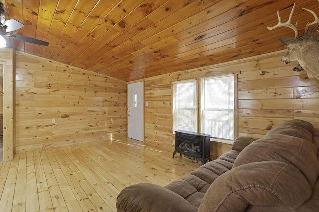 living room with ceiling fan, wood walls, hardwood / wood-style floors, vaulted ceiling, and wood ceiling