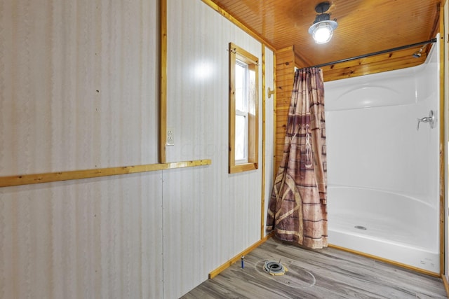 bathroom with a shower with shower curtain, hardwood / wood-style floors, wooden walls, and wood ceiling