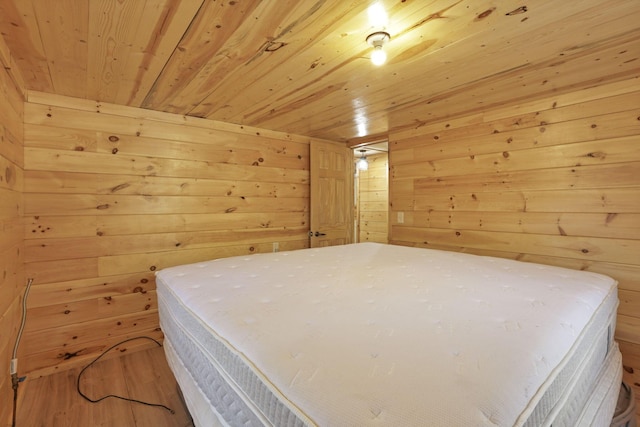 bedroom featuring wooden walls, hardwood / wood-style floors, and wood ceiling