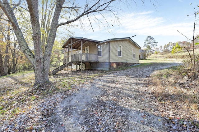 view of side of home featuring covered porch