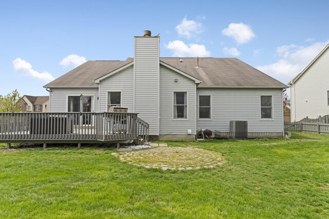 rear view of house featuring a deck, a yard, fence, and a chimney