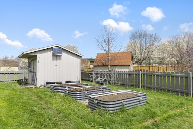 view of yard featuring an outbuilding, a garden, fence, and a storage shed