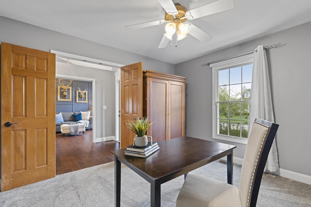 office space featuring wood finished floors, ceiling fan, and baseboards