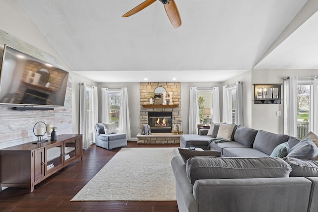 living room featuring ceiling fan, a fireplace, recessed lighting, vaulted ceiling, and dark wood-type flooring