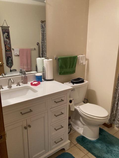 bathroom featuring tile patterned flooring, vanity, and toilet