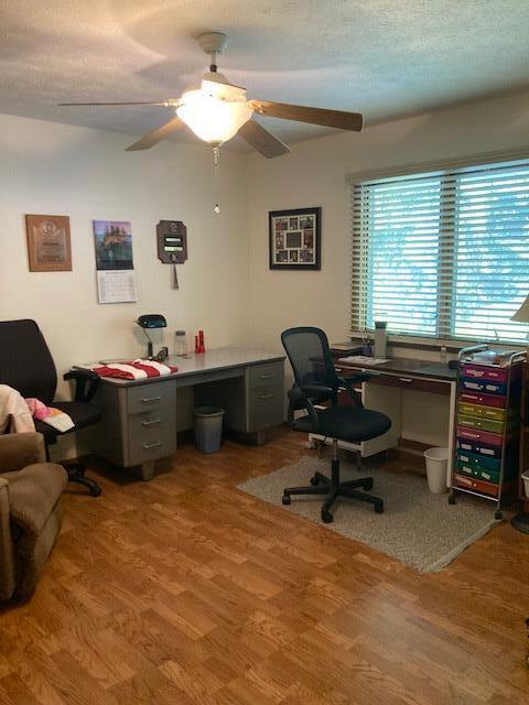 home office featuring ceiling fan, a textured ceiling, and hardwood / wood-style flooring